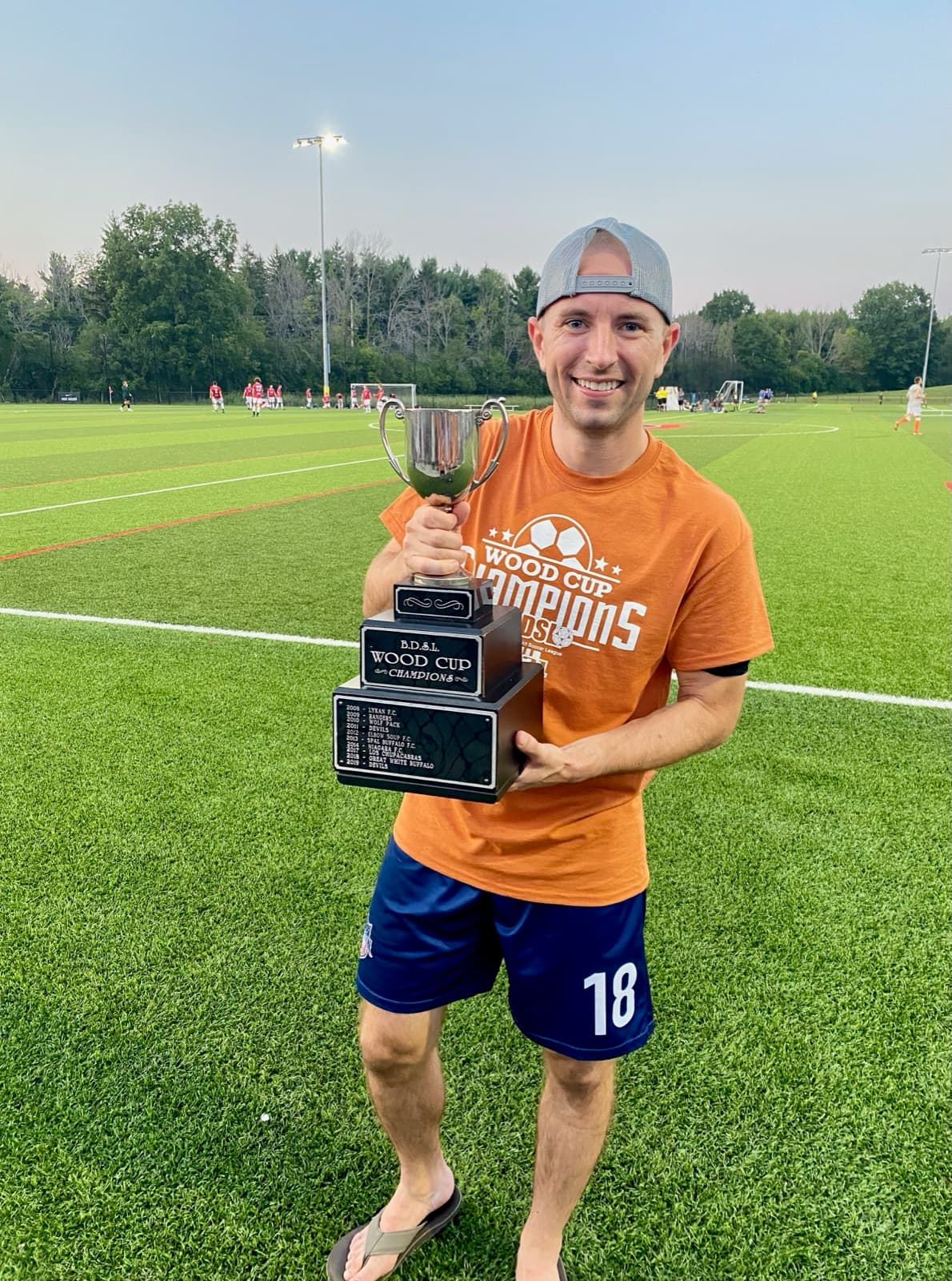Brett holding a rec league soccer championship trophy
