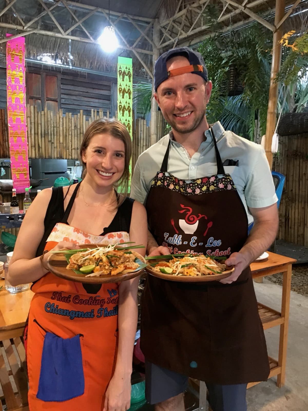 Brett and Erin holding the plates they cooked at a Thai cooking class